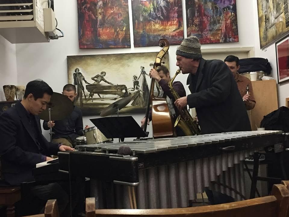 Dan leaning into the baritone over the vibraphone, gallery walls behind