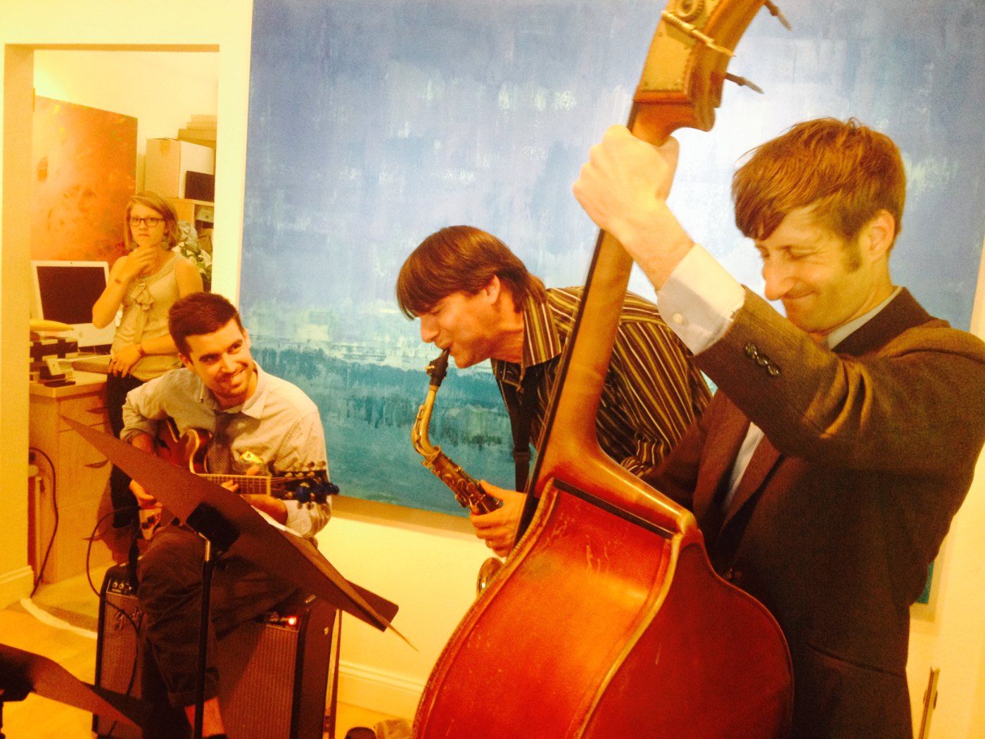 The trio playing before a blue painting